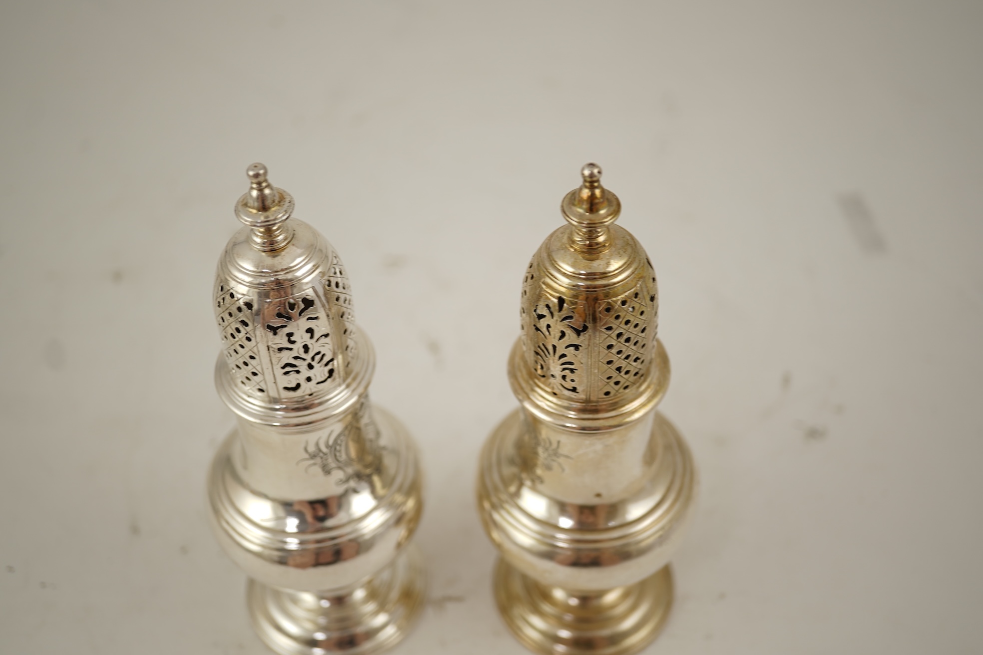 A pair of George II silver baluster sugar casters, by Samuel Wood